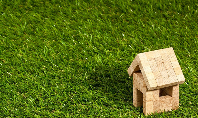 Photo of tiny block house on green grass