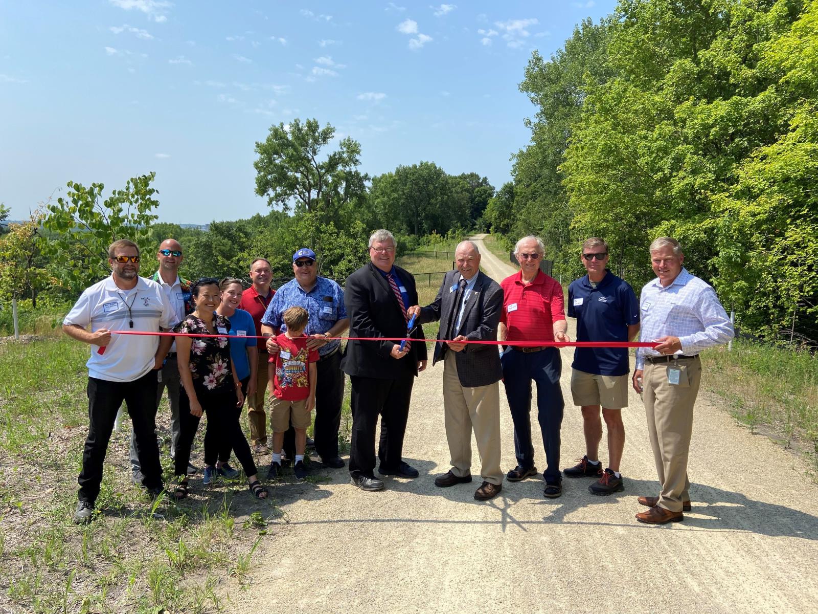 People standing on trail cutting ribbon