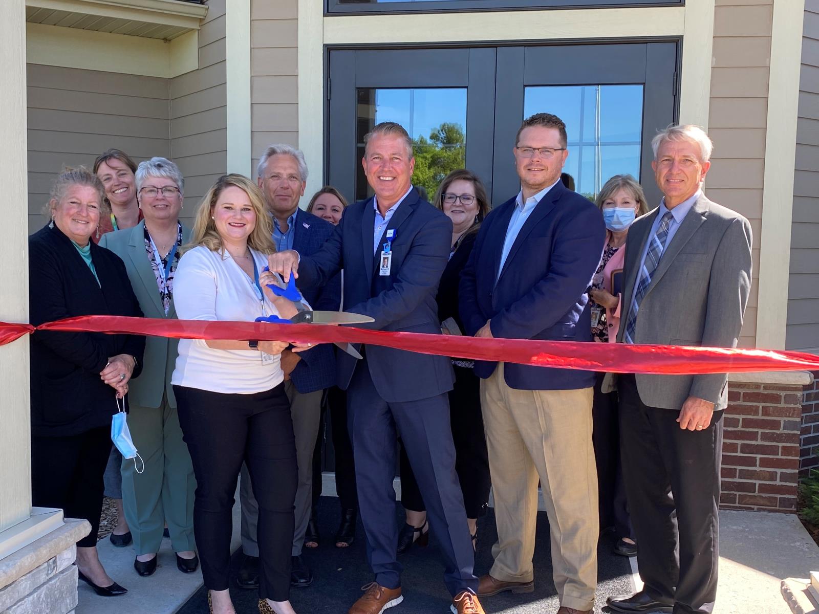 Image of group of people cutting ribbon to celebrate opening of Steiner Kelting Mental Wellness Facility